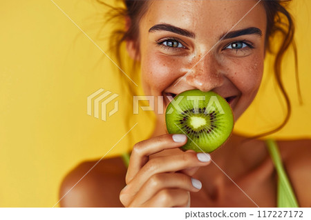 Vibrant Portrait of a Sportswoman Enjoying Kiwi Vibrant Portrait of a Sportswoman Enjoying Kiwi 117227172
