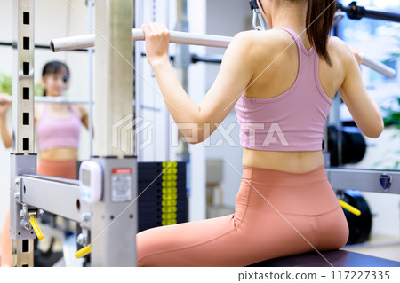 Woman working out at the gym, lat pulldown, female muscle training, workout Woman working out at the gym, lat pulldown, female muscle training, workout 117227335