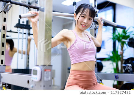 Woman working out at the gym, lat pulldown, female muscle training, workout Woman working out at the gym, lat pulldown, female muscle training, workout 117227481