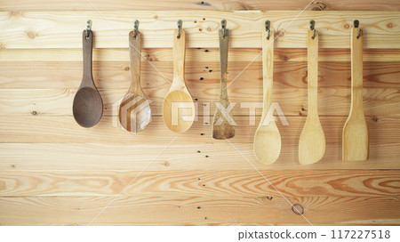 wooden spatula and spoon in different size hanging on wooden wall wooden spatula and spoon in different size hanging on wooden wall 117227518