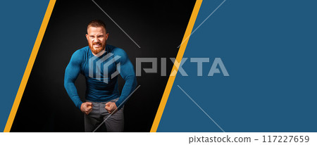 Biceps pumping. An aggressive man with an effort shows his biceps. Black background. Banner with copy space. The concept of bodybuilding Biceps pumping. An aggressive man with an effort shows his biceps. Black background. Banner with copy space. The concept of bodybuilding 117227659