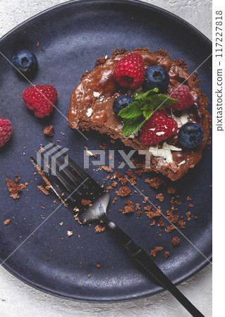 half-eaten chocolate tartlet, on a plate, stuffed with cottage cheese and berries, breakfast, homemade, no people, 117227818