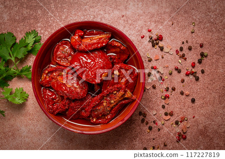 dried tomatoes, in a bowl, top view, on a brown background, 117227819