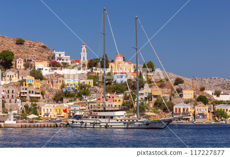 Bright colorful houses on the shore of the bay in the Greek fishing village Symi 117227877