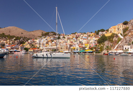 Bright colorful houses on the shore of the bay in the Greek fishing village Symi 117227880