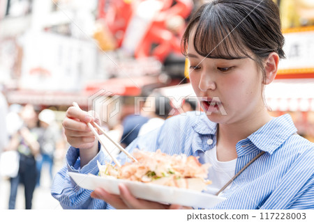 大阪府大阪市道頓堀，一位女士在戶外吃章魚燒 117228003