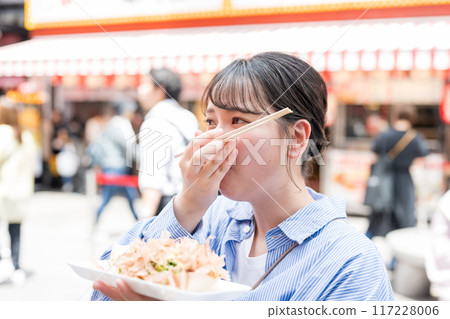 大阪府大阪市道頓堀，一位女士在戶外吃章魚燒 117228006
