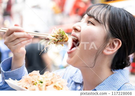 大阪府大阪市道頓堀，一位女士在戶外吃章魚燒 117228008