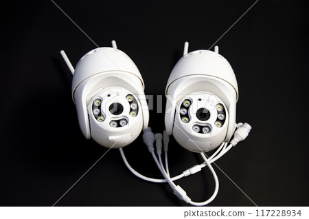 Two white IP cameras placed on a black background 117228934