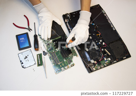 Top view. Technician repairing notebook computer, repairing motherboard and circuit. 117229727