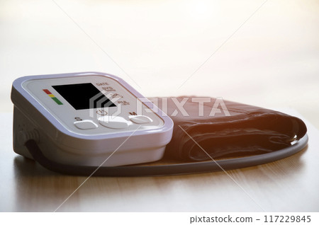 Blood pressure monitor placed on a wooden floor 117229845