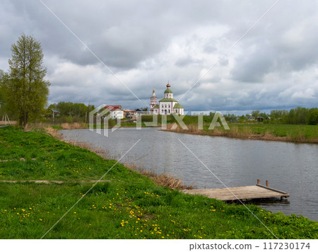 Wooden pier on the river against the background of the church. 117230174