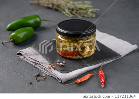 Pickled sliced jalapeno in a jar on dark background. Traditional meat snacks. Healthy fermented food 117231364