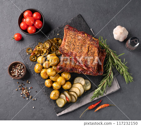 Grilled bbq pork ribs with fried baby potato, pickled cucumber and jalapeno and frech vegetables 117232150