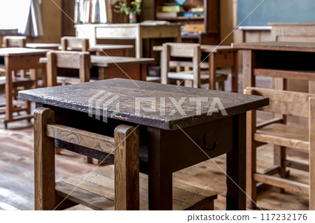 A nostalgic sight of retro desks shining black in a wooden classroom 117232176