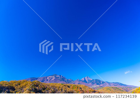 [Autumn material] Yatsugatake and blue sky during the autumn leaves season seen from Yatsugatake Ohashi Bridge [Yamanashi Prefecture] 117234139