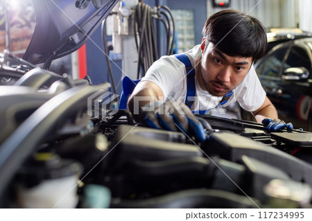 Repairman auto mechanic check for damage inside engine.  117234995