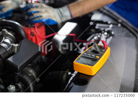 Repairman using handheld digital multimeter 117235000