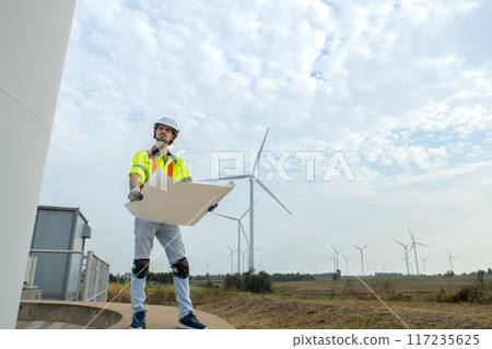 man engineer worker wearing safety uniform holding and reading blueprint man engineer worker wearing safety uniform holding and reading blueprint 117235625