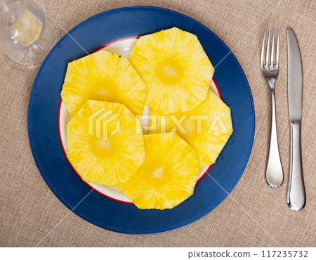 Beautifully sliced pineapple on white plate, serving pineapple on festive table Beautifully sliced pineapple on white plate, serving pineapple on festive table 117235732