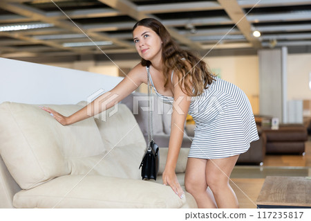 Positive girl is testing new furniture during visiting salon 117235817