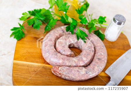 Raw Cumberland pork sausage with greens prepared for cooking 117235907