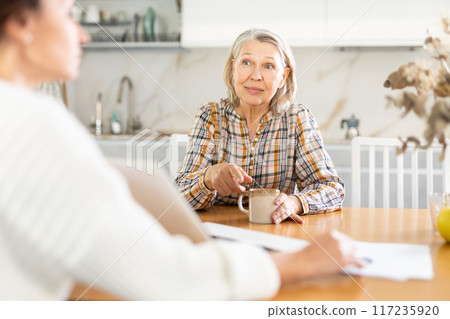 Real estate agent consulting elderly woman in home Real estate agent consulting elderly woman in home 117235920
