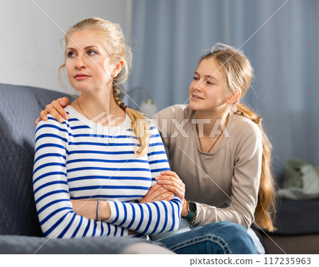 Upset woman sitting on sofa after quarrel 117235963