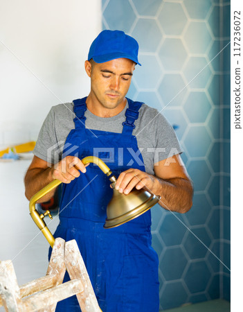Repairman assembling shower in bathroom of new apartment 117236072
