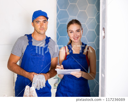 Man and woman in overalls in apartment during home improvement works Man and woman in overalls in apartment during home improvement works 117236089