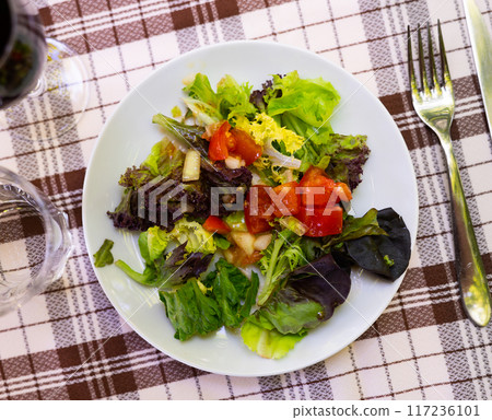 Vitamin salad of fresh vegetables, lettuce, olives, onion is prepared for guests of restaurant 117236101