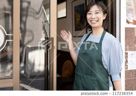 咖啡館門口微笑的女工作人員 咖啡館門口微笑的女工作人員 117236354