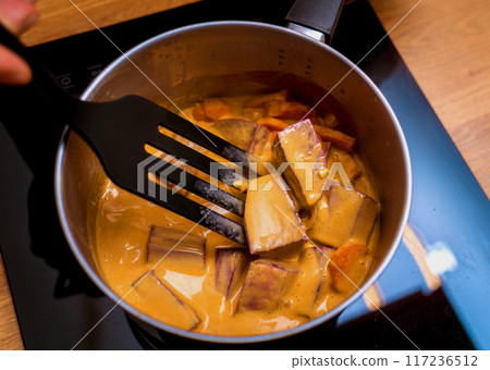 Chef at the kitchen preparing massaman curry with sweet potato and many spices Chef at the kitchen preparing massaman curry with sweet potato and many spices 117236512