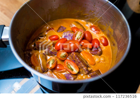 Chef at the kitchen preparing massaman curry with sweet potato and many spices Chef at the kitchen preparing massaman curry with sweet potato and many spices 117236516