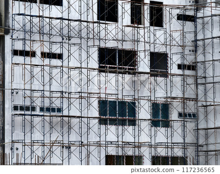 A tall building with numerous windows is being built 117236565