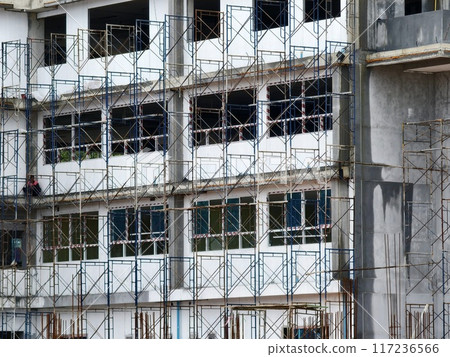 A tall building with numerous windows is being built A tall building with numerous windows is being built 117236566