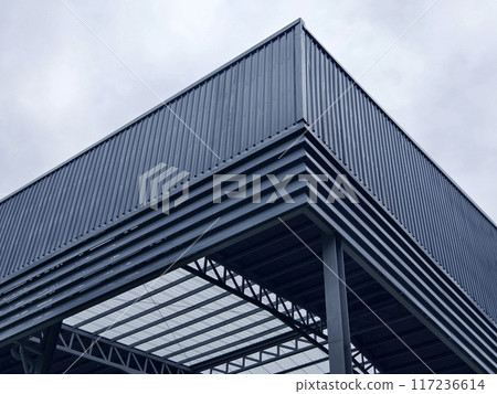 A large building with metal roof against a cloudy sky A large building with metal roof against a cloudy sky 117236614