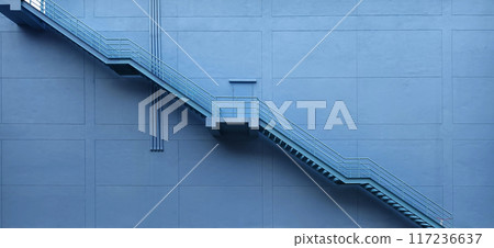 A set of stairs ascending a large blue wall 117236637