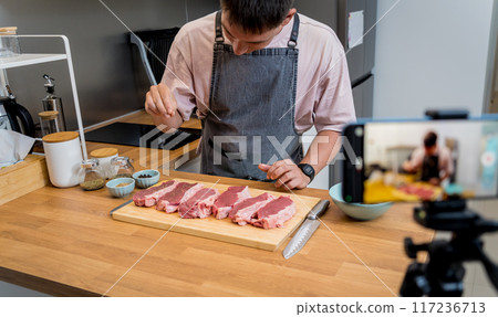 The chef is broadcasting live from workshop how to prepare a beef steaks on the electric grill The chef is broadcasting live from workshop how to prepare a beef steaks on the electric grill 117236713
