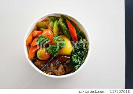 A bowl of food with a variety of vegetables and meat 117237018