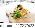 A close-up photo of a plate featuring a decadent fried banana dessert. 117237022