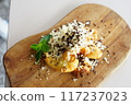 A close-up photo of a plate featuring a decadent fried banana dessert. 117237023