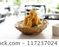 A close-up photo of a plate overflowing with golden fried calamari ring. 117237024