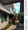 A narrow alleyway with a blue sky visible in the background. 117237030