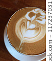 Close-up photo of a cappuccino with latte art in a ceramic cup on a concrete table. 117237031