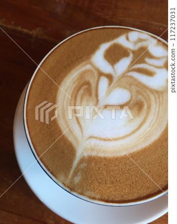 Close-up photo of a cappuccino with latte art in a ceramic cup on a concrete table. 117237031