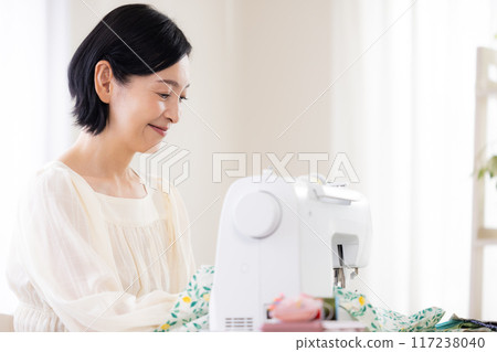 Hobby: Middle-aged woman sewing with a sewing machine 117238040