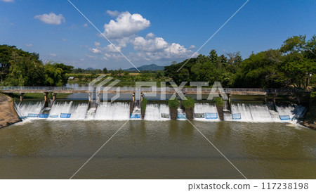 Aerial view of small spillway in Pa Daet district in Chiang Rai province of Thailand. Spillway, passage for surplus water over or around a dam when the reservoir itself is full. 117238198