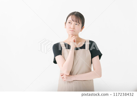 A female store clerk wearing an apron with a thinking expression 117238432