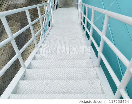 Metal stairs to blue building against sky and clouds 117238464
